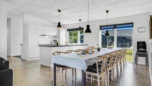 A modern kitchen with white cabinets, a central island, and pendant lighting. - Lovely home in Glesborg with sauna (Glesborg)