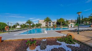 A swimming pool area with multiple pools, surrounded by palm trees and a landscaped garden with pebbles and flowers. - Rescator Resort 322 - One Bedroom Apartment, Sleeps 4 (Roses)