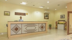 A reception desk with a sign, a potted plant, and a decorative fish tank.