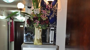 Un refrigerador con etiqueta de eficiencia energética, un microondas y un florero con flores encima.