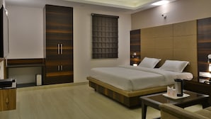 Ein modernes Hotelzimmer mit einem großen Bett, einem Schreibtisch und einem Kleiderschrank.