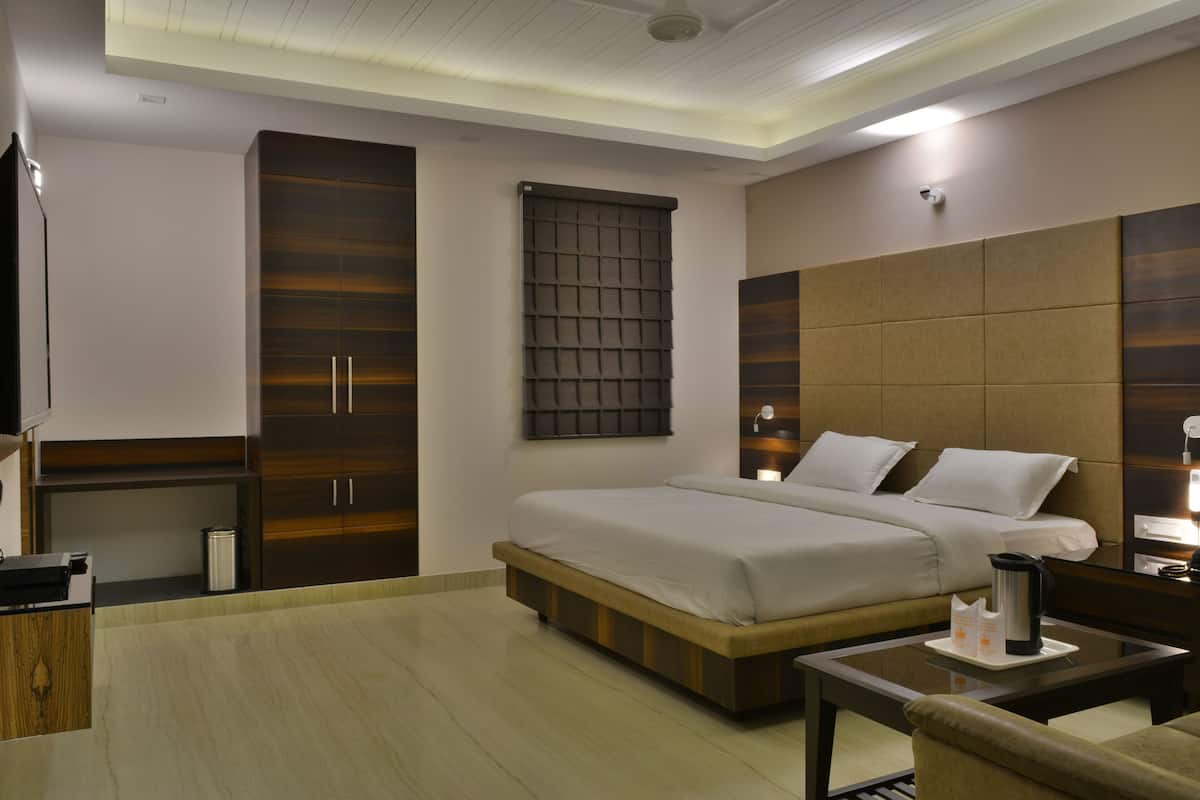 Una habitación de hotel moderna con una cama grande, un escritorio y un armario.