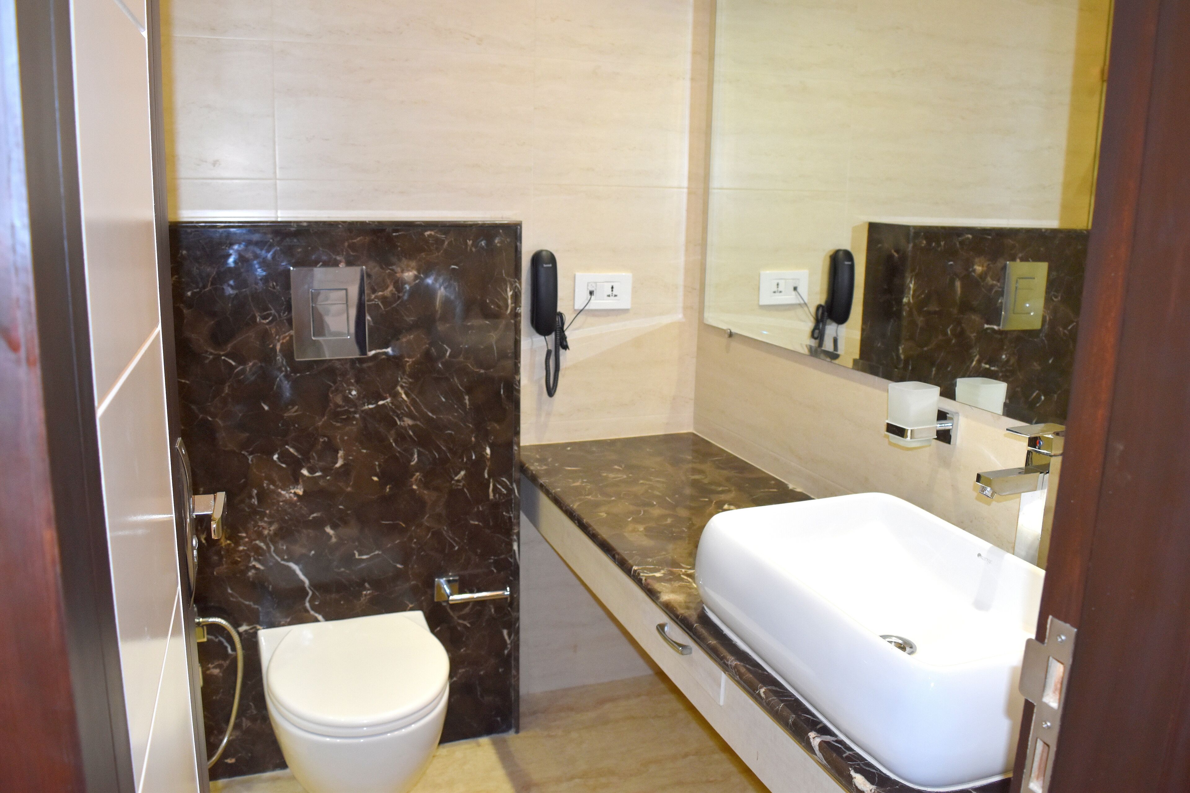 A bathroom with a white toilet, a sink, and a mirror.