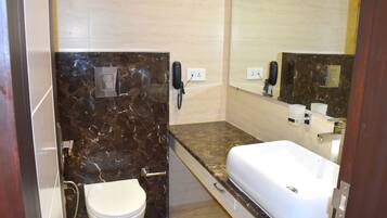 A bathroom with a white toilet, a sink, and a mirror.