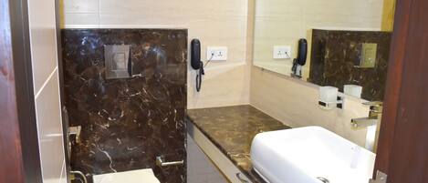 A bathroom with a white toilet, a sink, and a mirror.