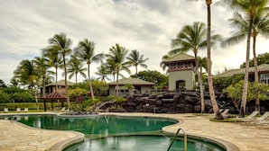 A resort pool area with a hot tub, palm trees, and a building with a tiled roof. - Private and Quiet, Luxury Family-Friendly unit in Fairways at Mauna Lani (Waimea)