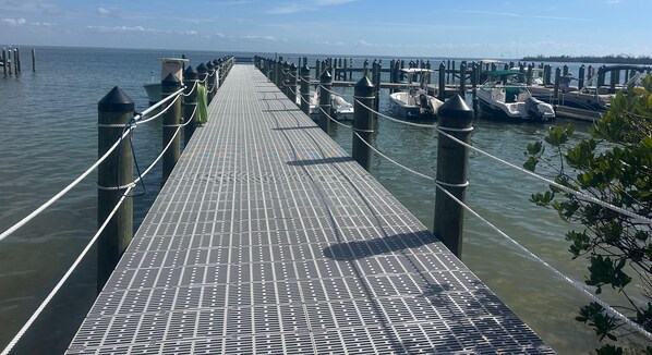 Un muelle que se adentra en aguas tranquilas, con barcos amarrados al final.