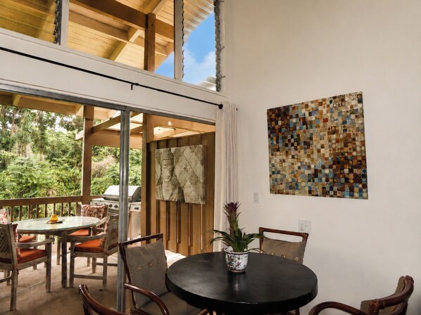 An indoor dining area with a round table, chairs, and a potted plant.