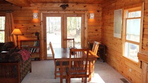 A wooden cabin interior with a dining table, chairs, a sofa, and a lamp. - Hang out with Moose! Log Cabin near RMNP/Columbine Lake (Grand Lake)