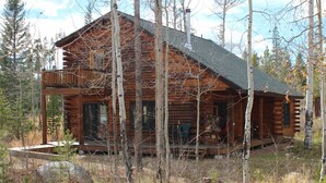 A log cabin with a porch and a chimney, surrounded by trees. - Hang out with Moose! Log Cabin near RMNP/Columbine Lake (Grand Lake)