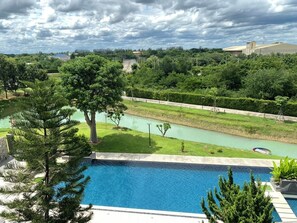 Ein Pool mit Blick auf einen Fluss und umliegendes Grün.
