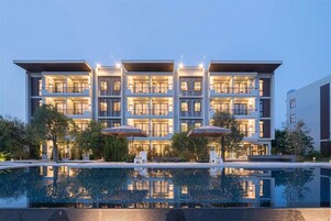 Una piscina al aire libre, sillones reclinables de piscina