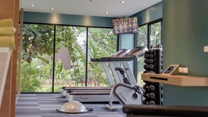 A gym with exercise equipment, a treadmill, and a stationary bike. - Green Ville Laguna Hotel (Sung Noen)