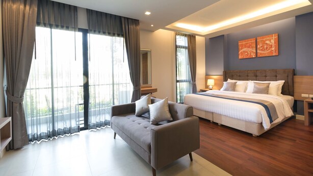 Une chambre moderne avec un grand lit, un canapé et un bureau.