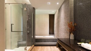 Une salle de bain moderne avec une douche à l’italienne, une baignoire et un grand miroir.
