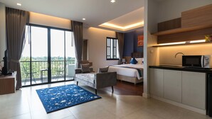 Une chambre moderne avec un grand lit, un bureau et un balcon offrant une vue agréable.