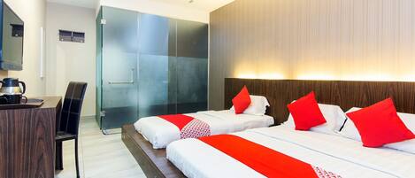 A hotel room with two beds, a desk, a chair, and a shower area.