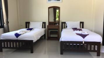 Habitación de hotel con dos camas, un escritorio pequeño y un espejo.