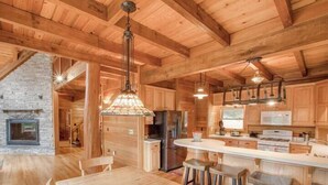 A wooden interior with a kitchen, dining area, and a fireplace. - Ten Mile Cabin Sleeps 16! Best Deal on AirBNB (Ten Mile)