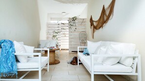 Un salon moderne avec des meubles blancs, une table basse en bois et une décoration murale.