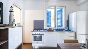 Une cuisine de taille réduite équipée d’une cuisinière à gaz, d’un four et d’un réfrigérateur.