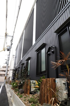 A modern building with vertical siding and large windows. - Hostel Taichi-House (Osaka)