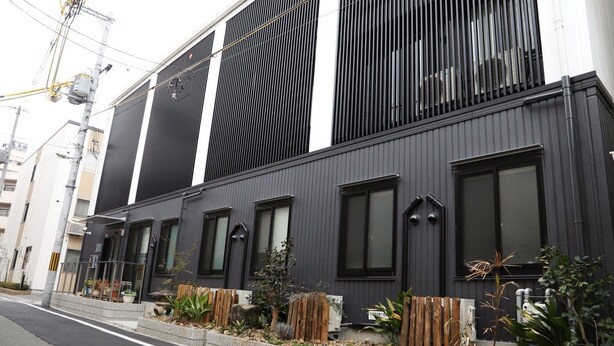 Un edificio moderno con ampie vetrate e una facciata scura.
