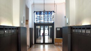 Un hall d’hôtel doté d’un plancher en bois, d’un comptoir de réception et d’un panneau indiquant l’emplacement du service en chambre et des autres commodités.