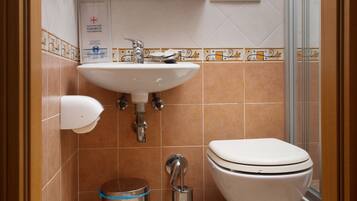 Un bagno con lavandino, wc e doccia.