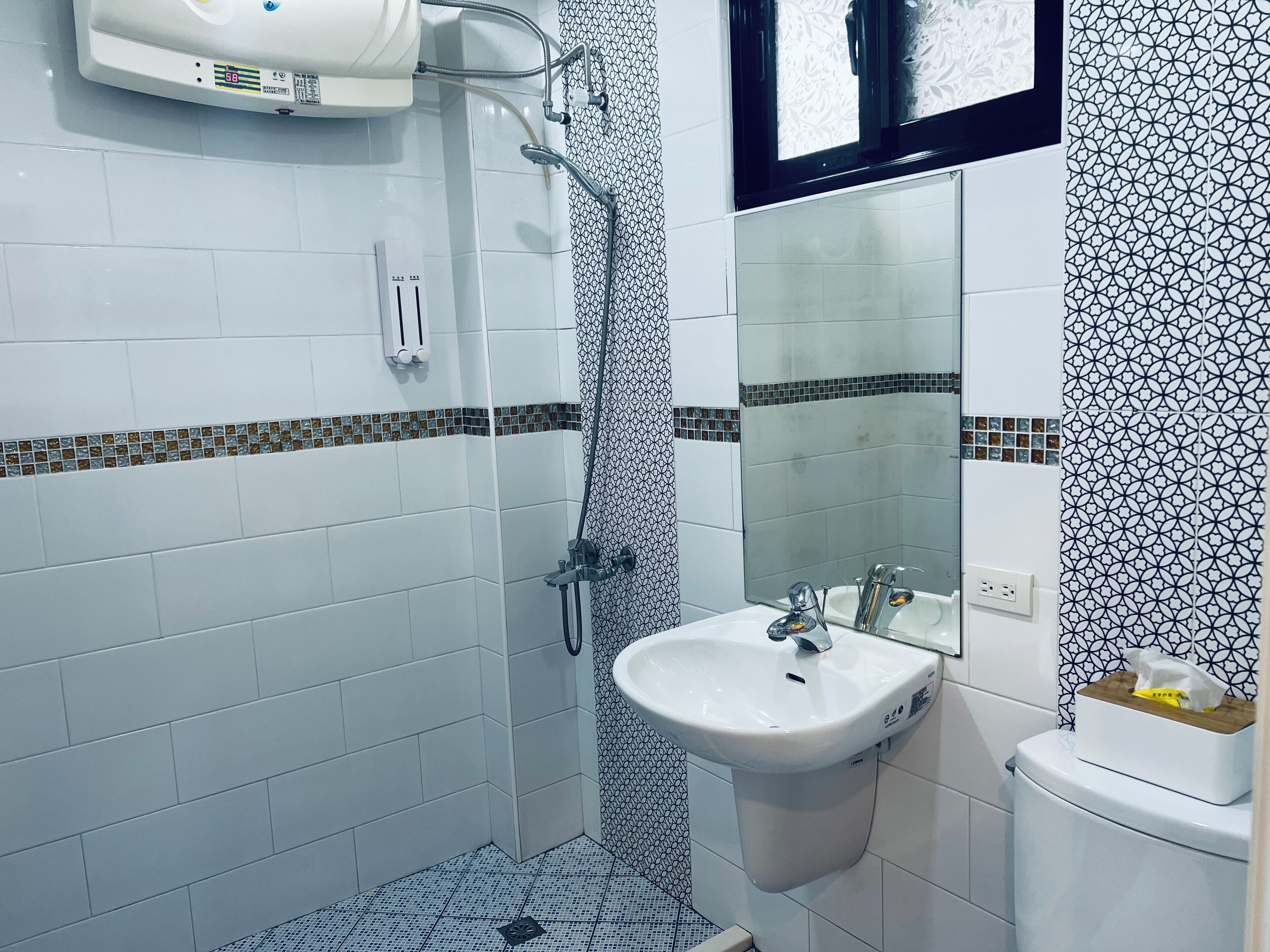 Een badkamer met een douche, wastafel en toilet.