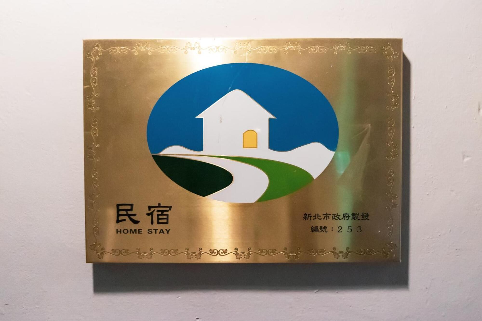A plaque with a house icon, "HOME STAY" text, and a number "253".