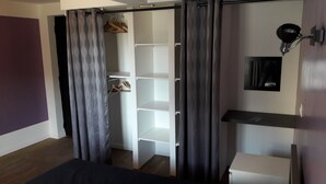A bedroom with a wardrobe, a bed, a bedside table, and a wall-mounted shelf. - very nice house, near downtown (Dol-de-Bretagne)