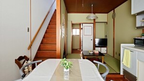 Una cocina compacta con una mesa de comedor, microondas y un refrigerador pequeño.