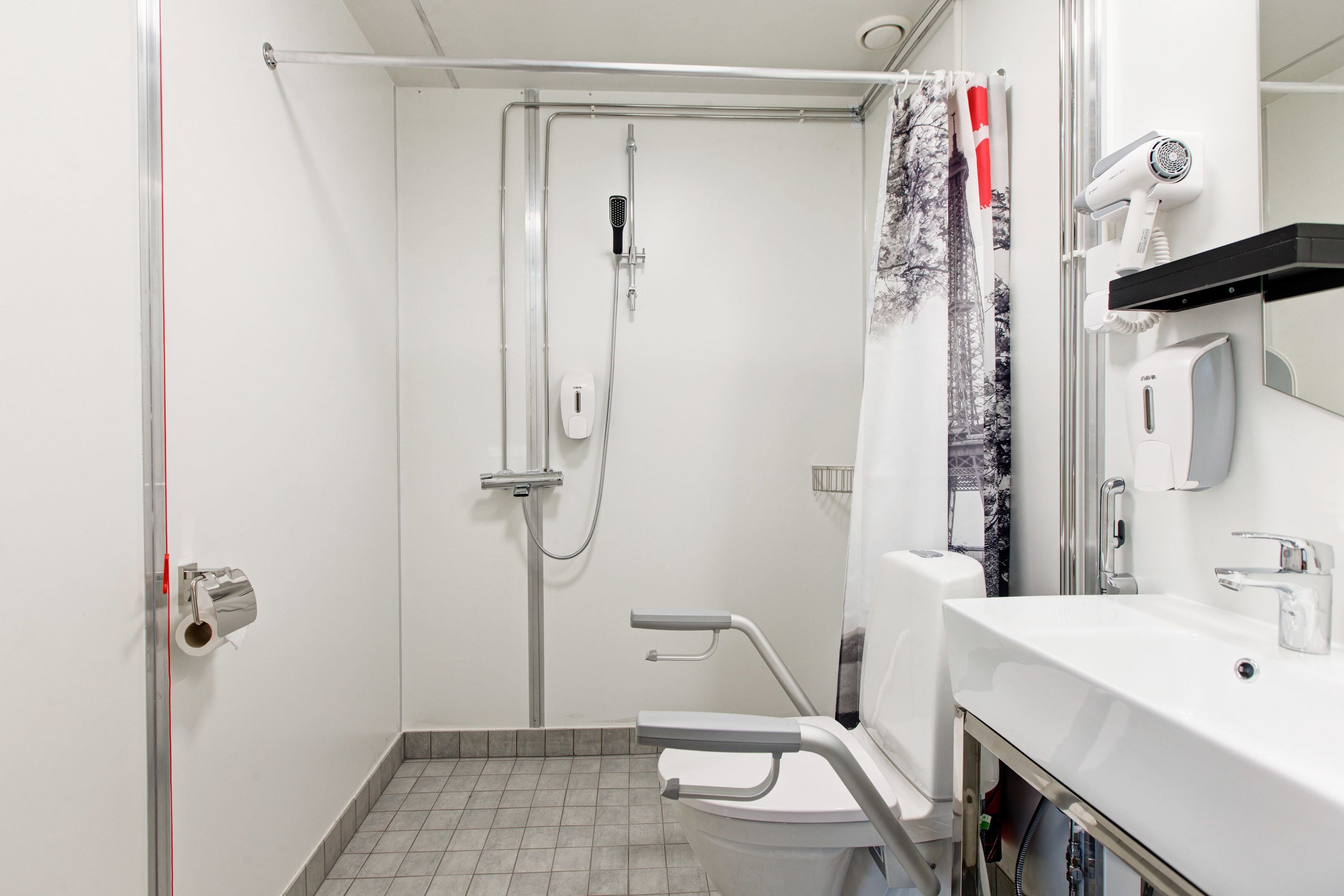 A bathroom with a shower, toilet, and sink.
