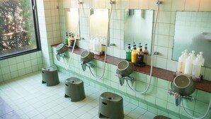 Un baño público con varios lavamanos, espejos y artículos de tocador.