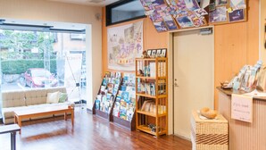 Un interior acogedor con un sofá, una estantería de madera y un tablón de anuncios con varios objetos sujetos.