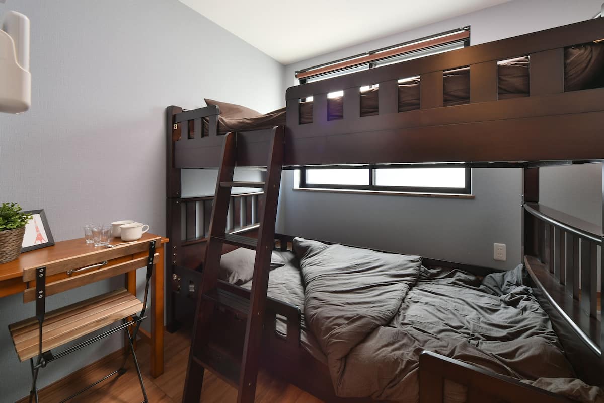 A bunk bed room with a desk and ladder.