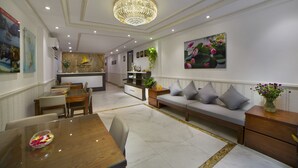 A modern hotel lobby with a dining area, a sofa, and a chandelier. - Galliot Central Hotel (Hanoi)