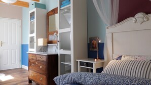 Un dormitorio con cama, cómoda, armario y mesita de noche.