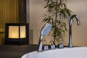 A bathroom with a modern shower, a wall-mounted light fixture, and a potted plant. - Shiki Suites - Kyoto Umekoji (Kyoto)