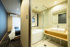 A modern hotel room with a large bed, a separate bathroom with a bathtub, and a large mirror above the sink. - Shiki Suites - Kyoto Umekoji (Kyoto)