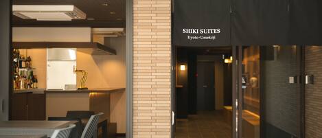 A hotel entrance with a sign for 'SHIKI SUITES Kyoto-Umekoji'.