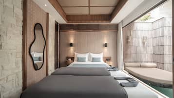A modern hotel room with a large bed, a small seating area, and a view of the outdoors.