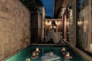 A poolside area with a table set for dining, candles, and a decorative centerpiece. - La Vie Villa Seminyak by Ini Vie Hospitality (Legian)