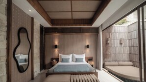 A modern bedroom with a large bed, a bench, a mirror, and a view of a garden. - La Vie Villa Seminyak by Ini Vie Hospitality (Legian)