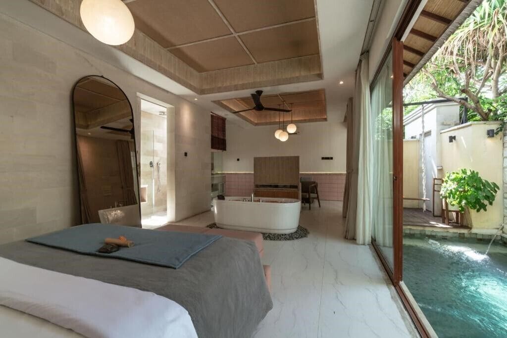 Ein Schlafzimmer mit Bett, Bad, Küche und Pool.