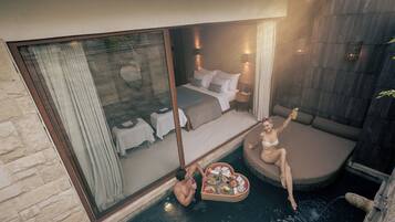 Un dormitorio con un ventanal grande, una cama y una mesita con comida.