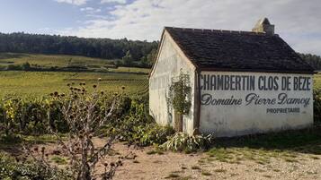 Ein kleines Gebäude mit einem Schild, auf dem „CHAMBERTIN CLOS DE BEZE Domaine Pierre Damoy PROPRIETAIRE“ steht.