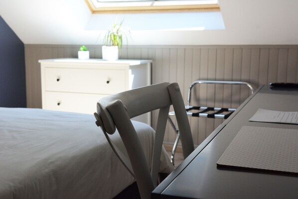 A bedroom with a bed, a desk with a chair, a white dresser, and a skylight. - Les Plumes (Gilly-les-Citeaux)