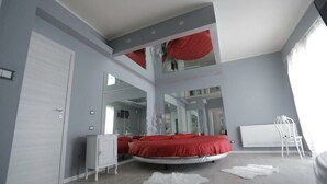 Une chambre à coucher avec un lit, une armoire, un miroir et un radiateur.